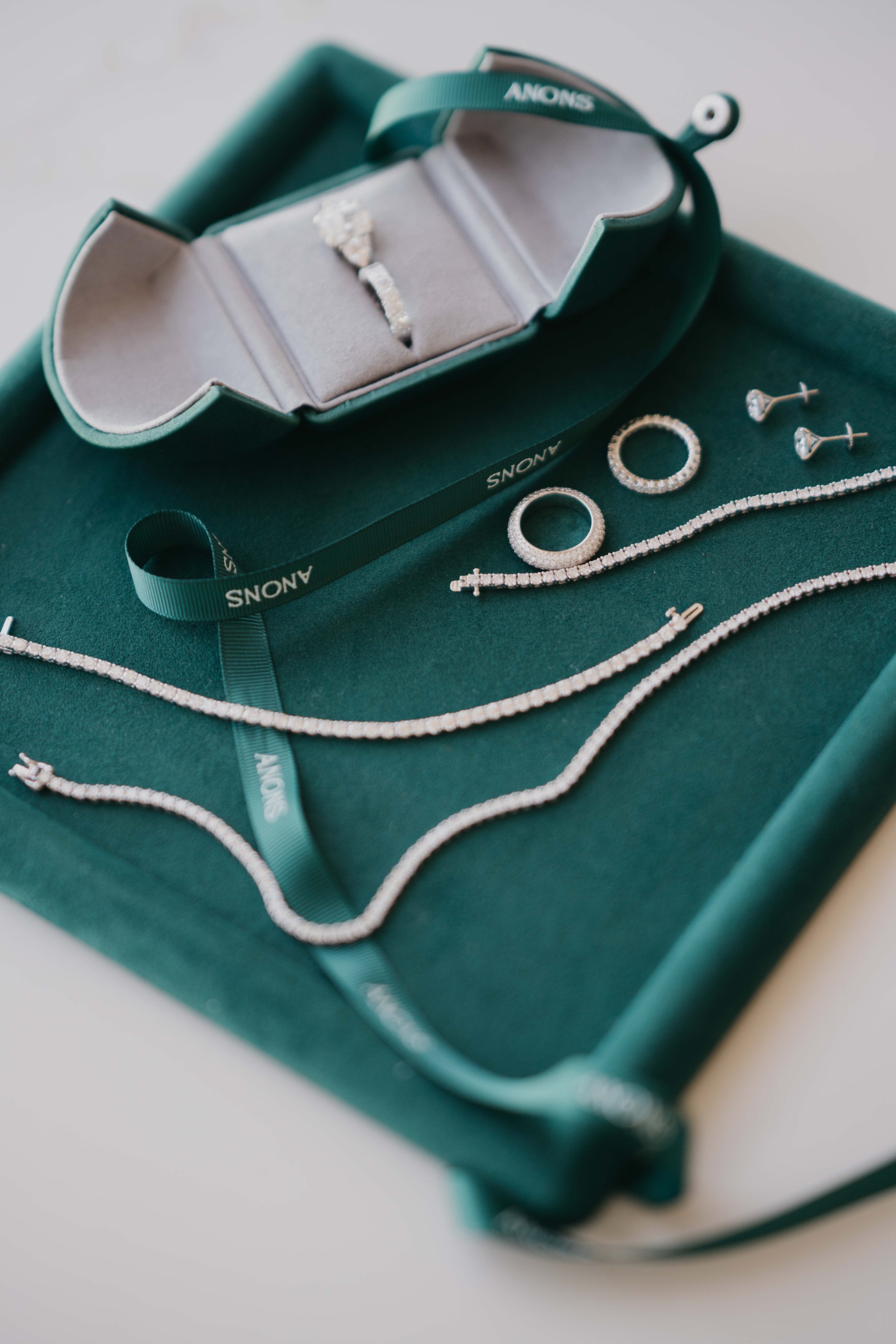 Jewelry set on a green tray with 'Anons' branding