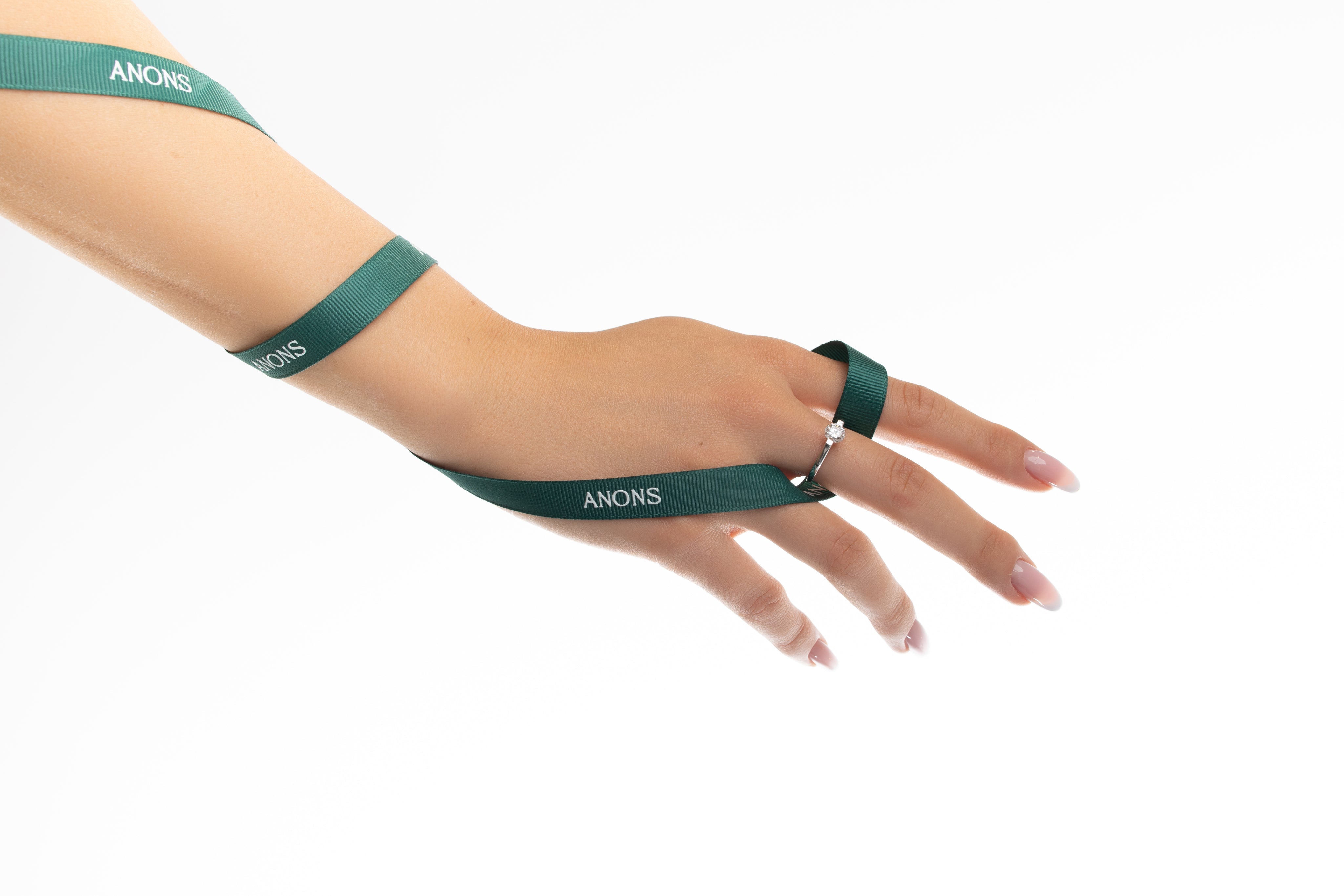Hand wearing a green wristband with 'SANKI' branding on a white background